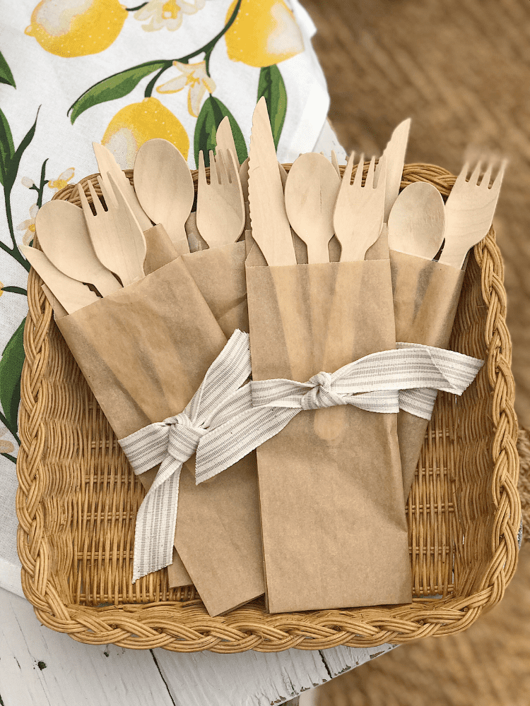 bamboo utensils served inside brown sandwich bags and tied with a ribbon 