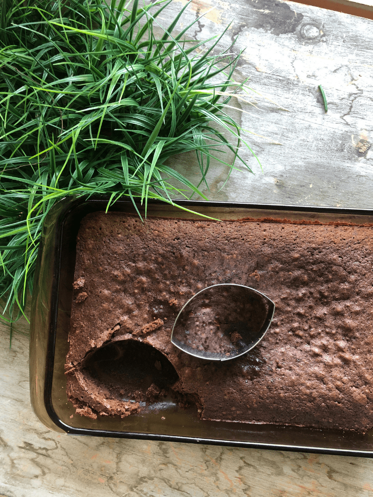 pan of brownies and a football shaped cookie cutter to cut brownies in football shapes