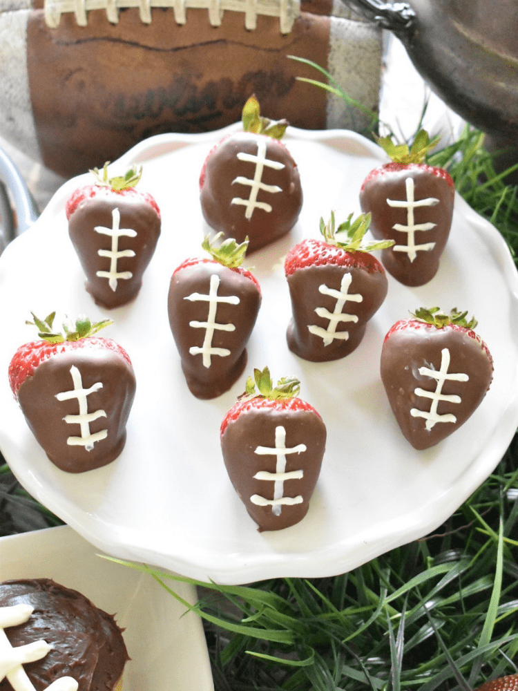 chocolate dipped strawberries with white "threads" piped on with white frosting to resemble footballs 