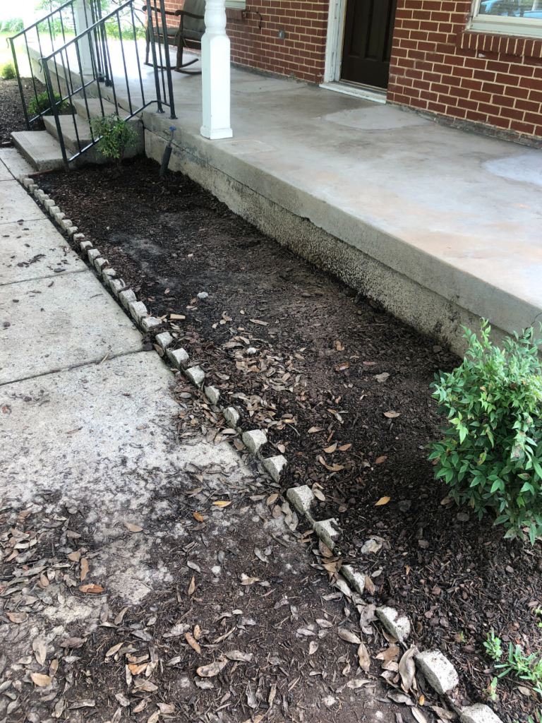 empty flower beds in front of house