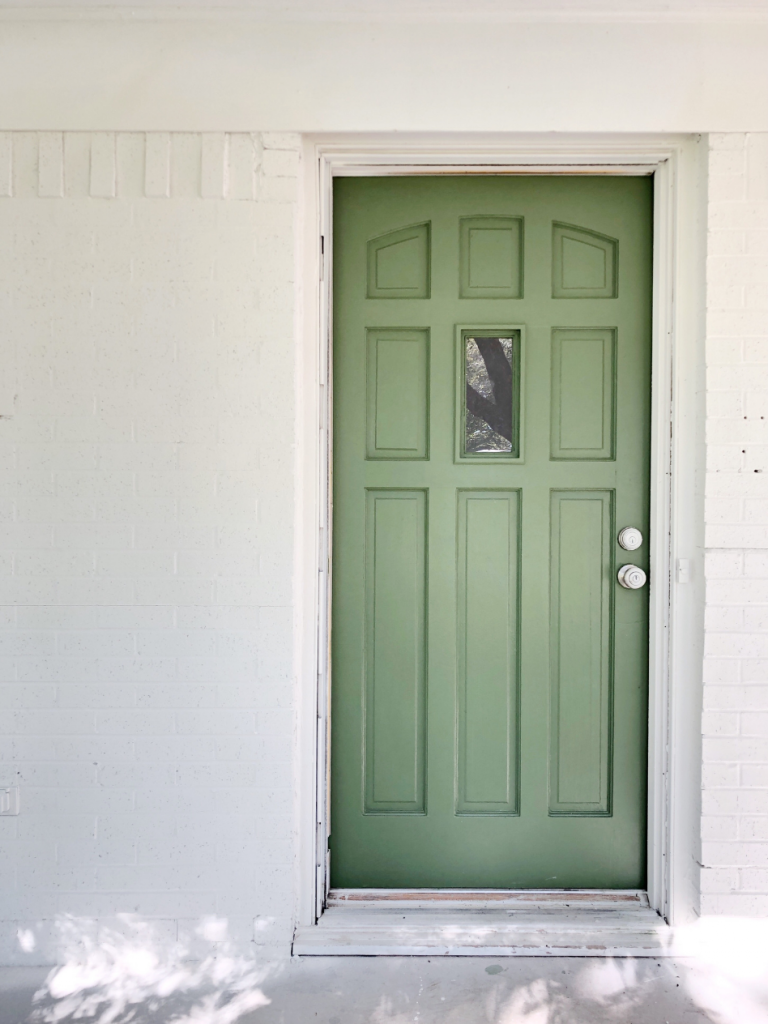 green front door on white brick house