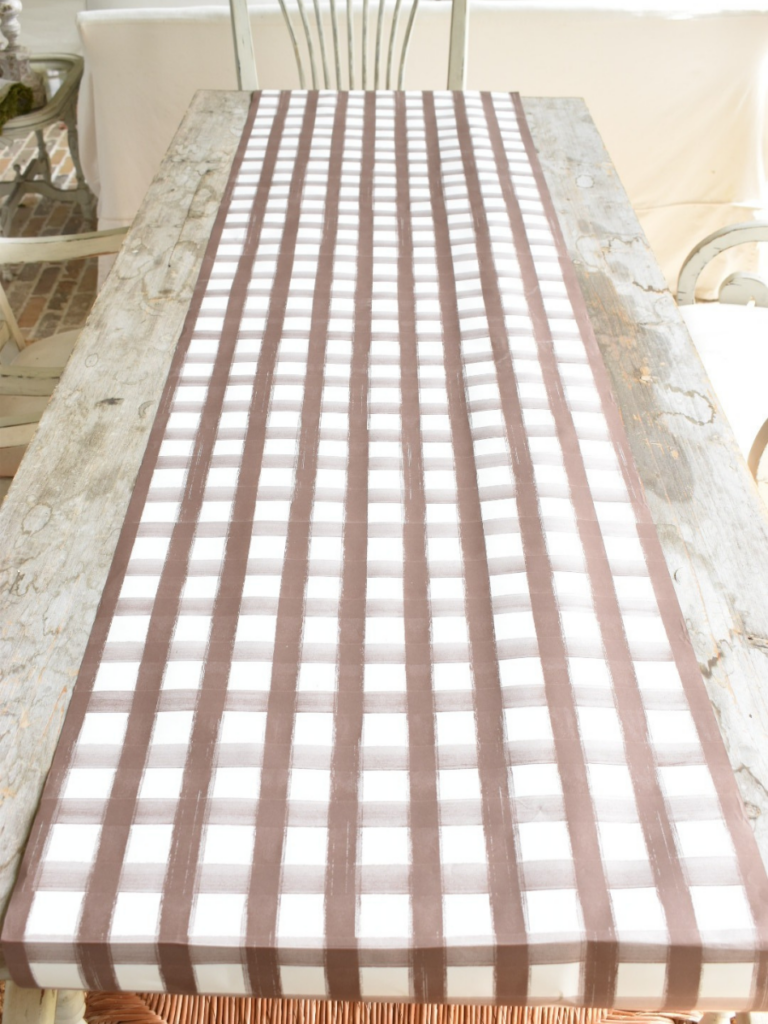 brown and white plaid paper table runner on outdoor rustic long dining table