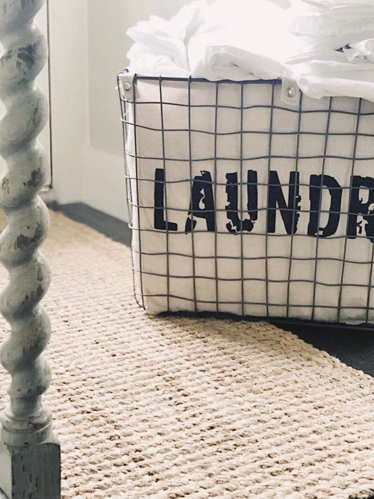 wire basket with liner that says LAUNDRY on jute rug 