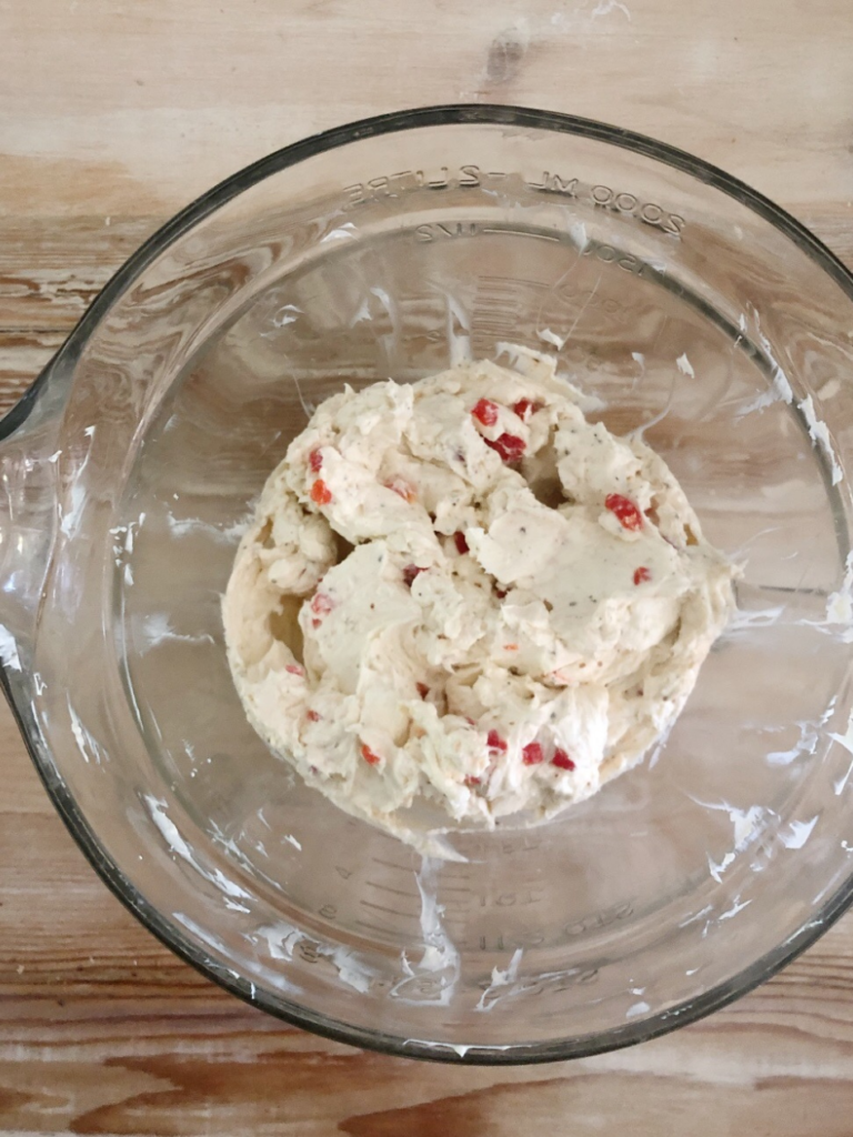 cream cheese ball sitting inside glass measuring bowl