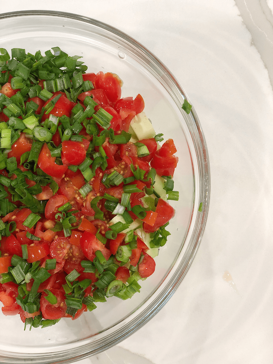 clear bowl with chopped tomatoes cucumbers green onion