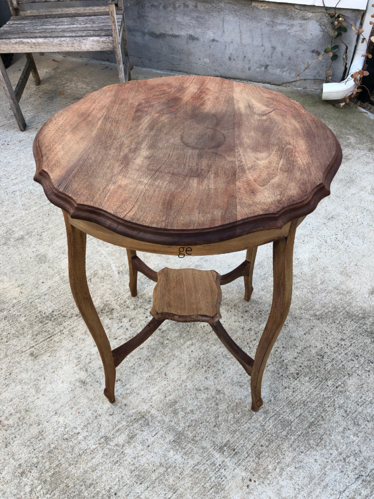 small round dark wood side table after oven cleaner method stain stripping on concrete driveway