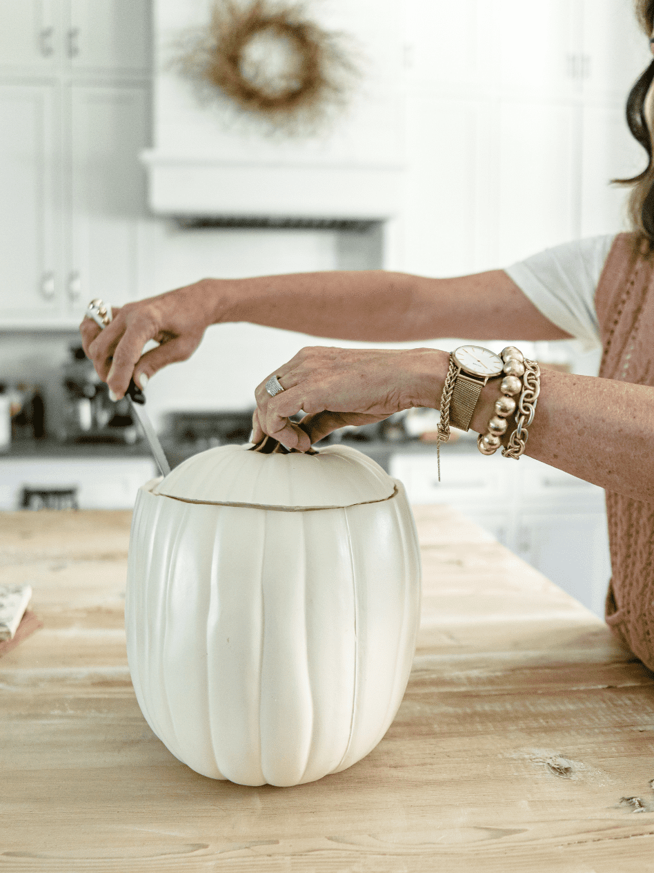 white faux pumpkin with top being cut off for a faux pumpkin ice bucket