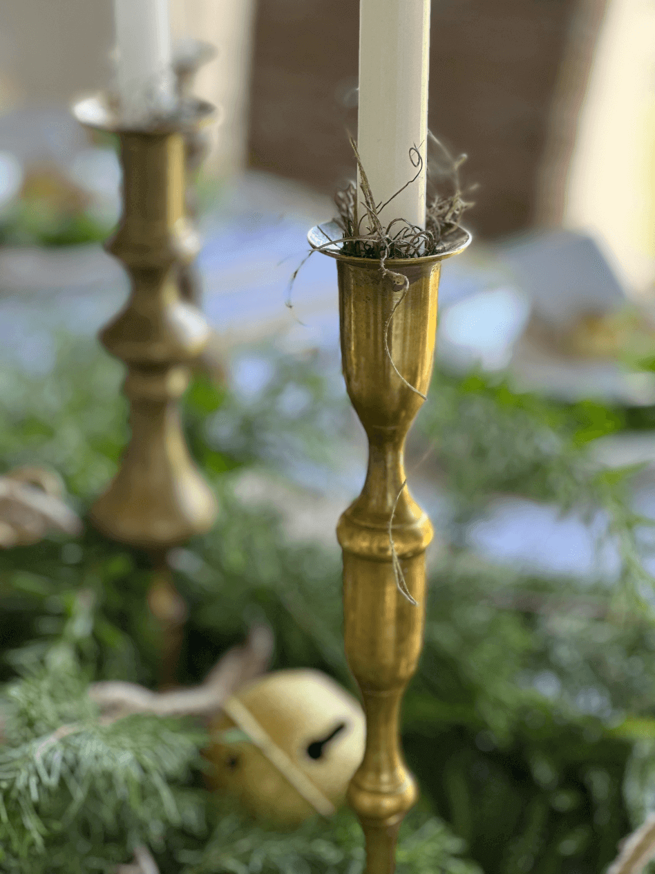 up close shot of brass candlestick with ivory taper