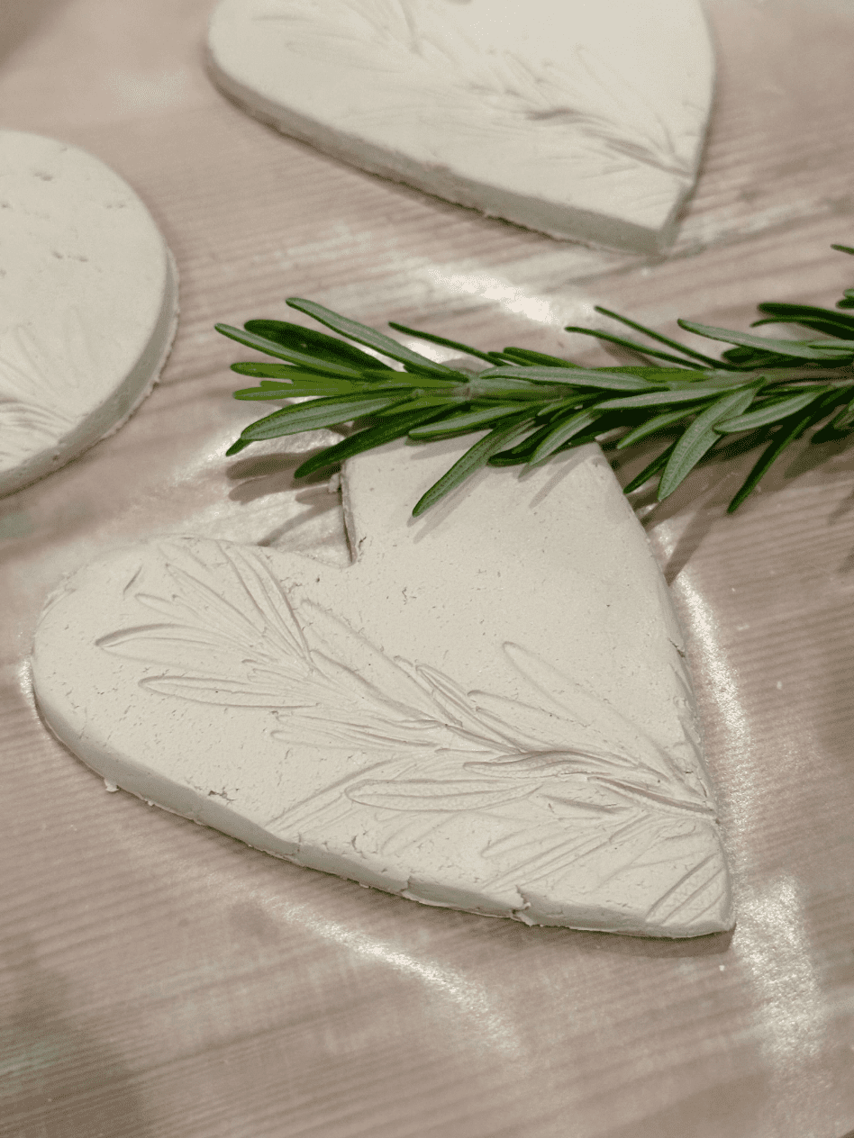 heart shaped air dry clay ornament embossed with a sprig of rosemary