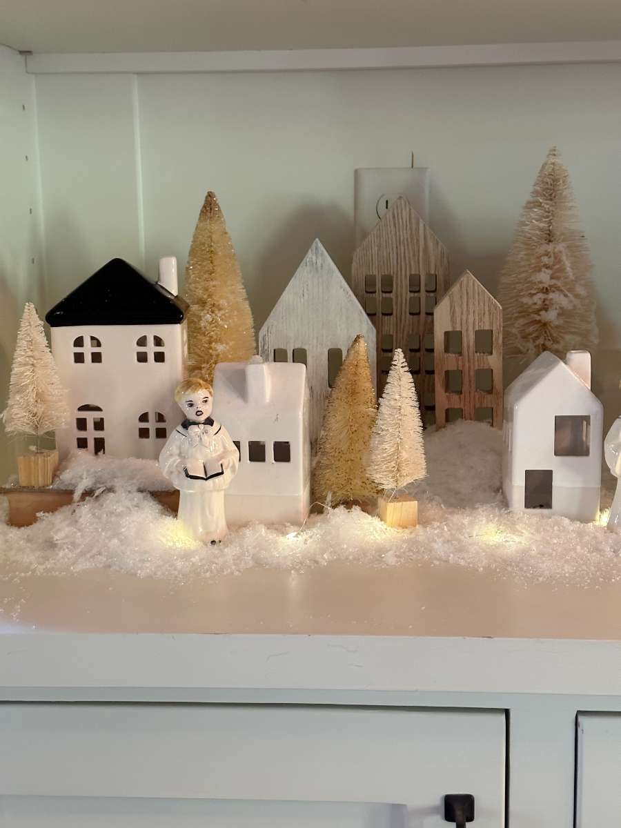 christmas village inside bookcase shelf with white houses vintage carolers and fake snow candlelight home tour