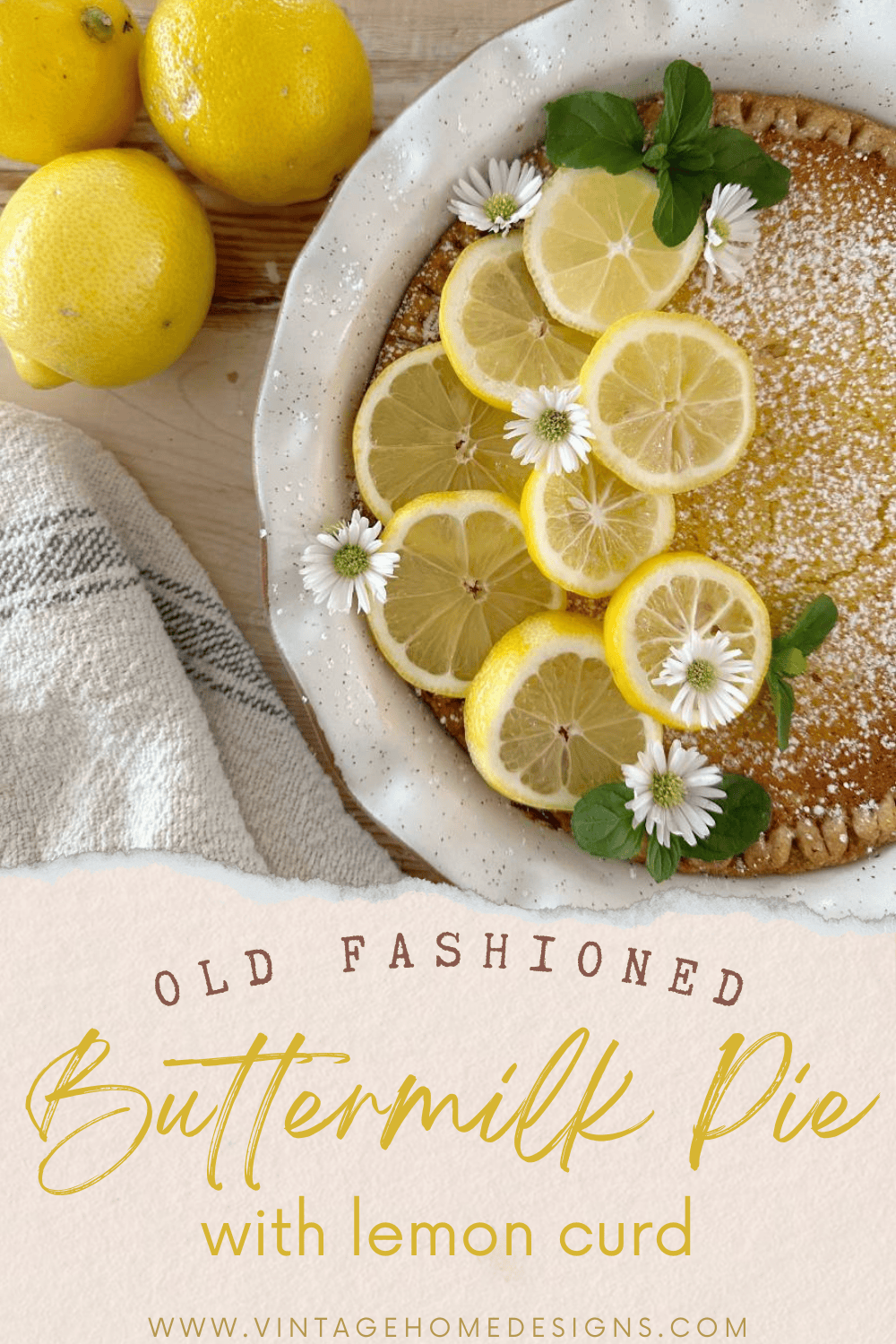 A buttermilk pie with lemon curd garnished with lemon slices and small white flowers is shown in a rustic setting. Fresh lemons and a striped cloth napkin are in the background. Text over the image reads "Old Fashioned Buttermilk Pie with lemon curd" from "VINTAGEHOMEDESIGNS.COM".