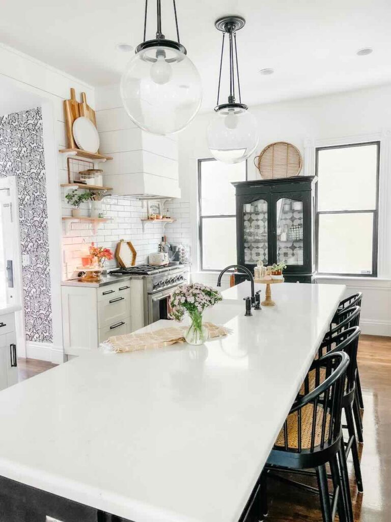 large island with white countertop black barstools