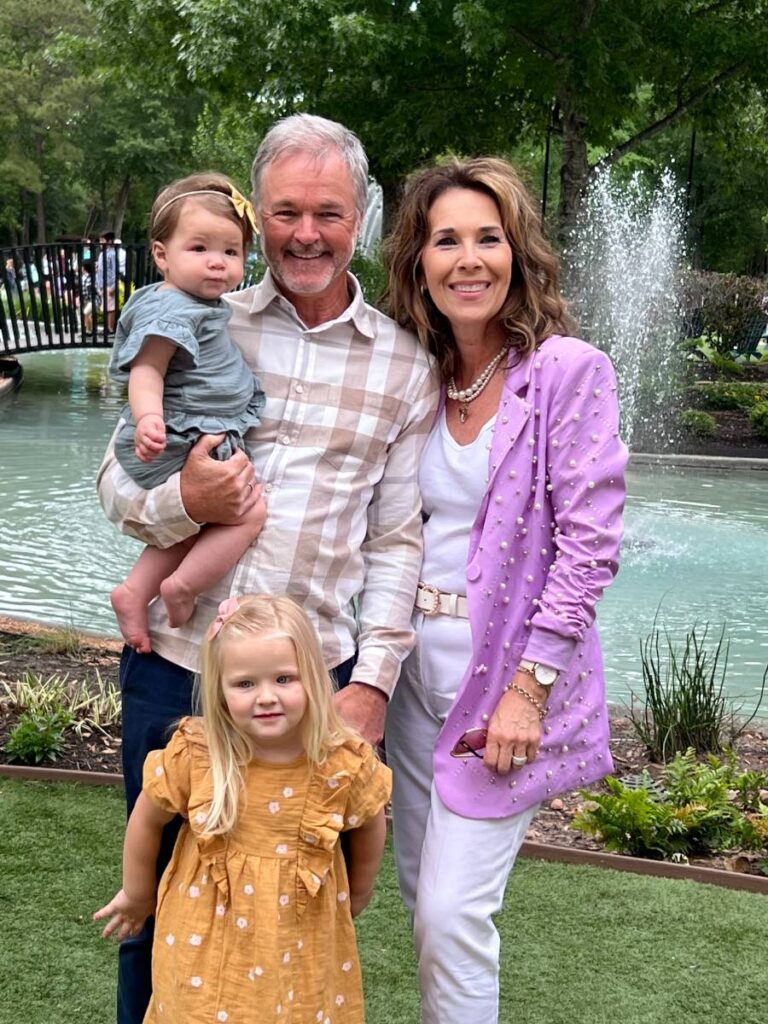 Male female and infant and toddler girl in front of water fountain