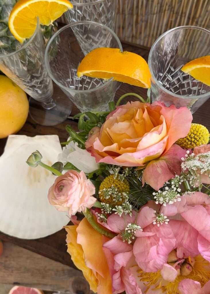 bright colored flower arrangement beside seashell for tropical table scape