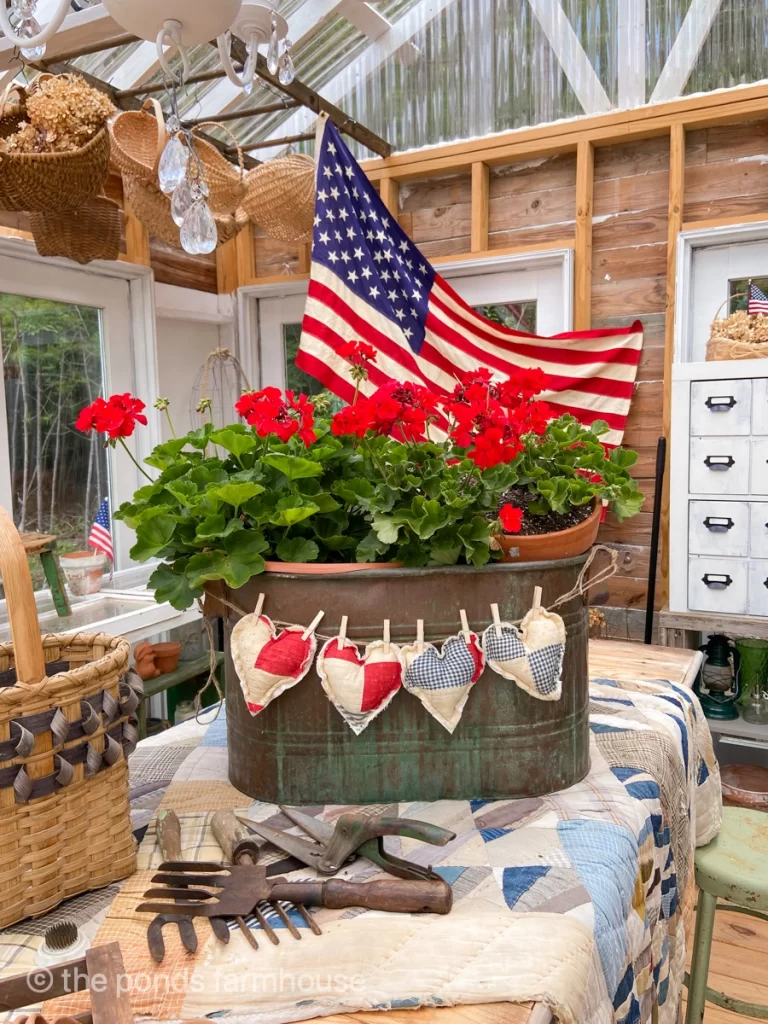 patriotic decor in a greenhouse large flag and red white and blue quilt hearts