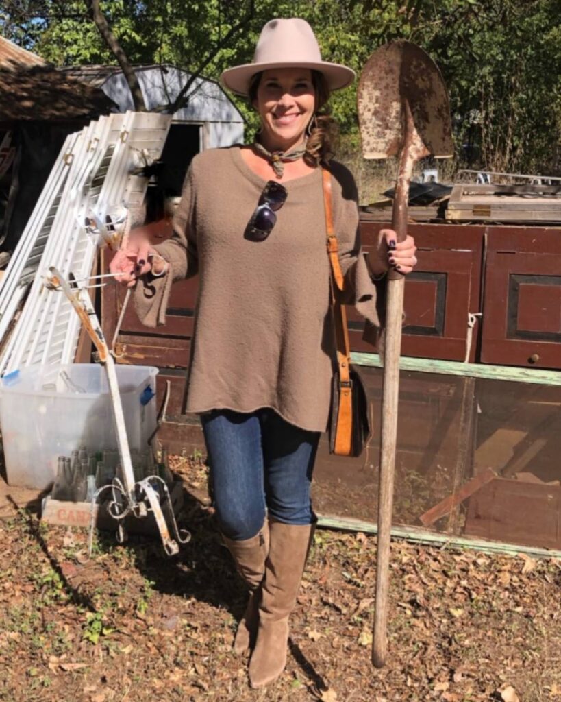 woman at flea market holding thrifted treasures