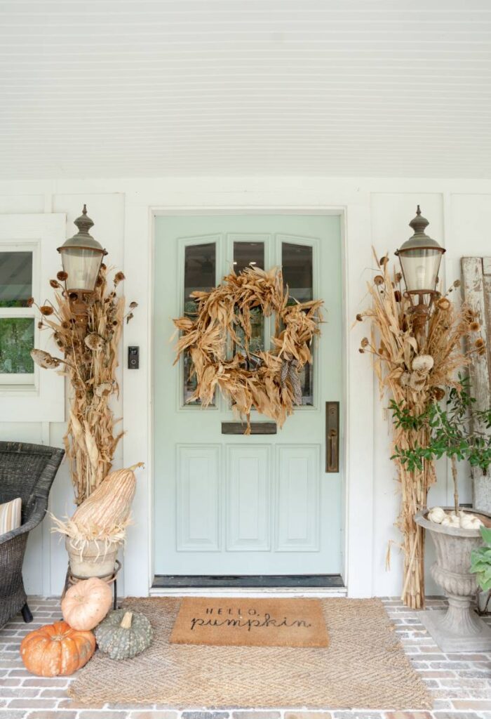 blue green front door cornstalks either side cornhusk wreath on door