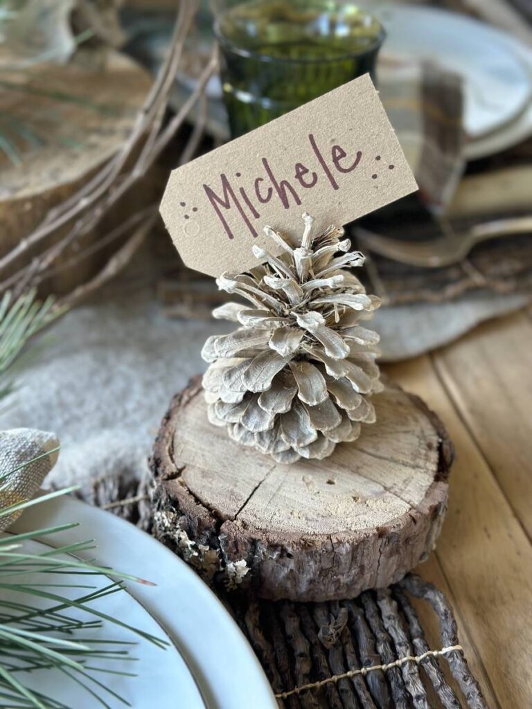 small wood slice with pinecone on top and name card tucked into pinecone