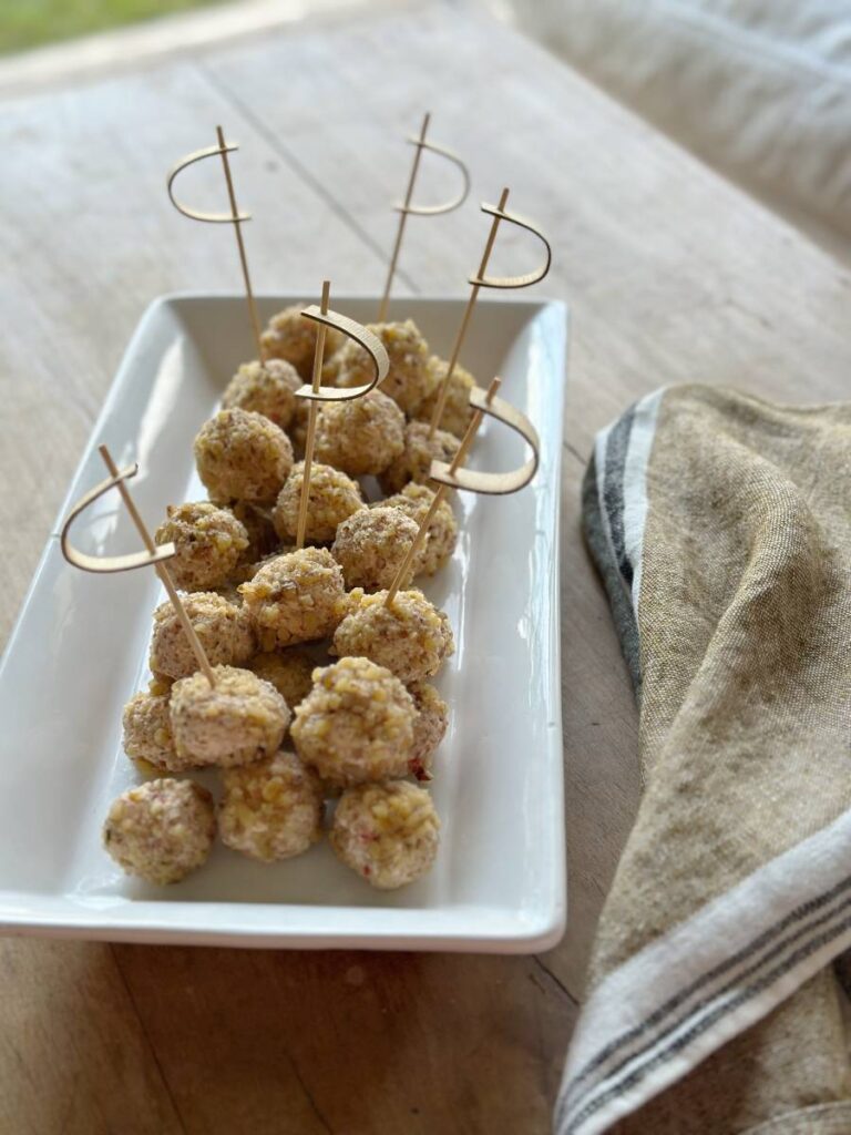 white rectangle platter filled with mini cheeseballs with decorative picks