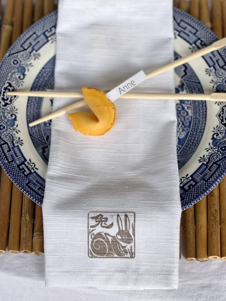 chinese themed place setting bamboo placemat blue asian dinner plate white napkin with chinese symbol chopsticks fortune cookie for place card