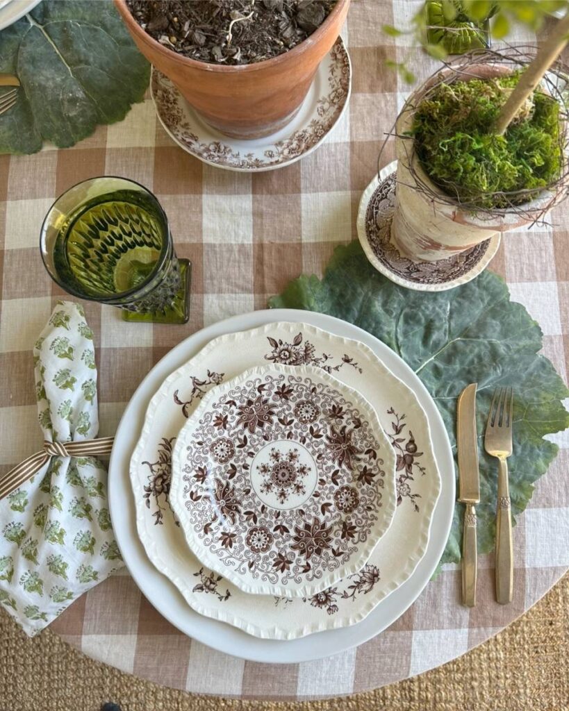 brown transferware plate green block print napkin gold flatware on cabbage leaf placemat for spring place setting