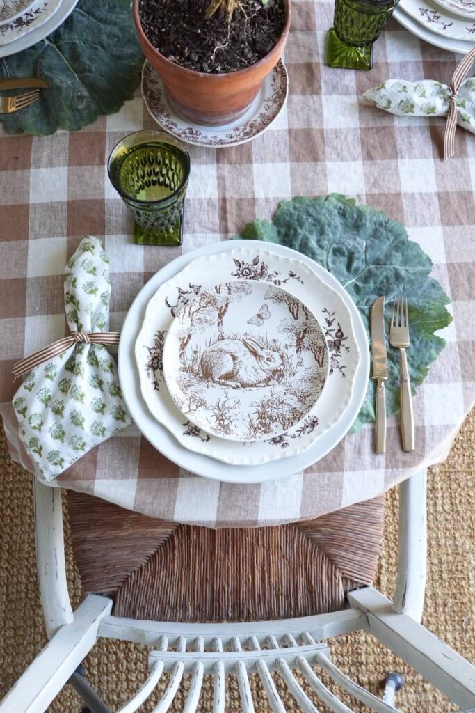 brown pattern bunny plate green block print napkin gold flatware on cabbage leaf placemat for spring place setting