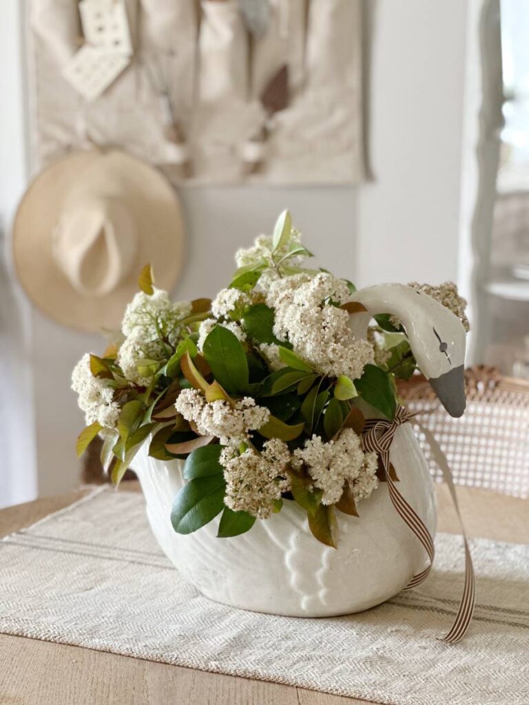 vintage swan vase with flowering branches for table centerpiece