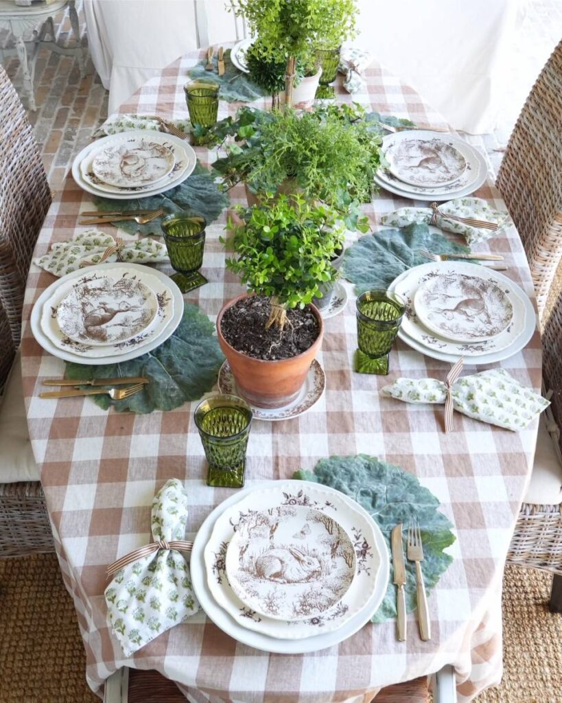 brown and white check tablecloth green print napkin brown bunny plate on cabbage leaf placemats at 6 place settings topiaries for centerpiece