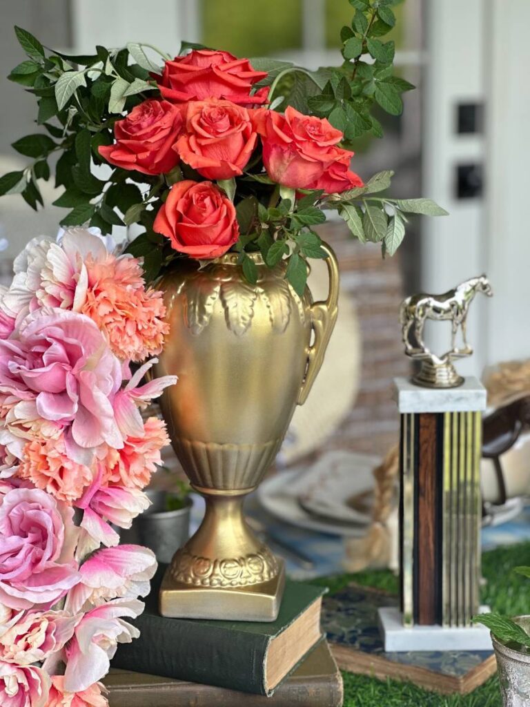 gold cup trophy filled with bright orange roses horse trophy and horseshoe shaped floral decor for Kentucky Derby table centerpiece