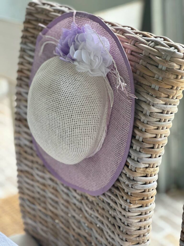 purple and white fancy hat on back of chair for Kentucky Derby table setting