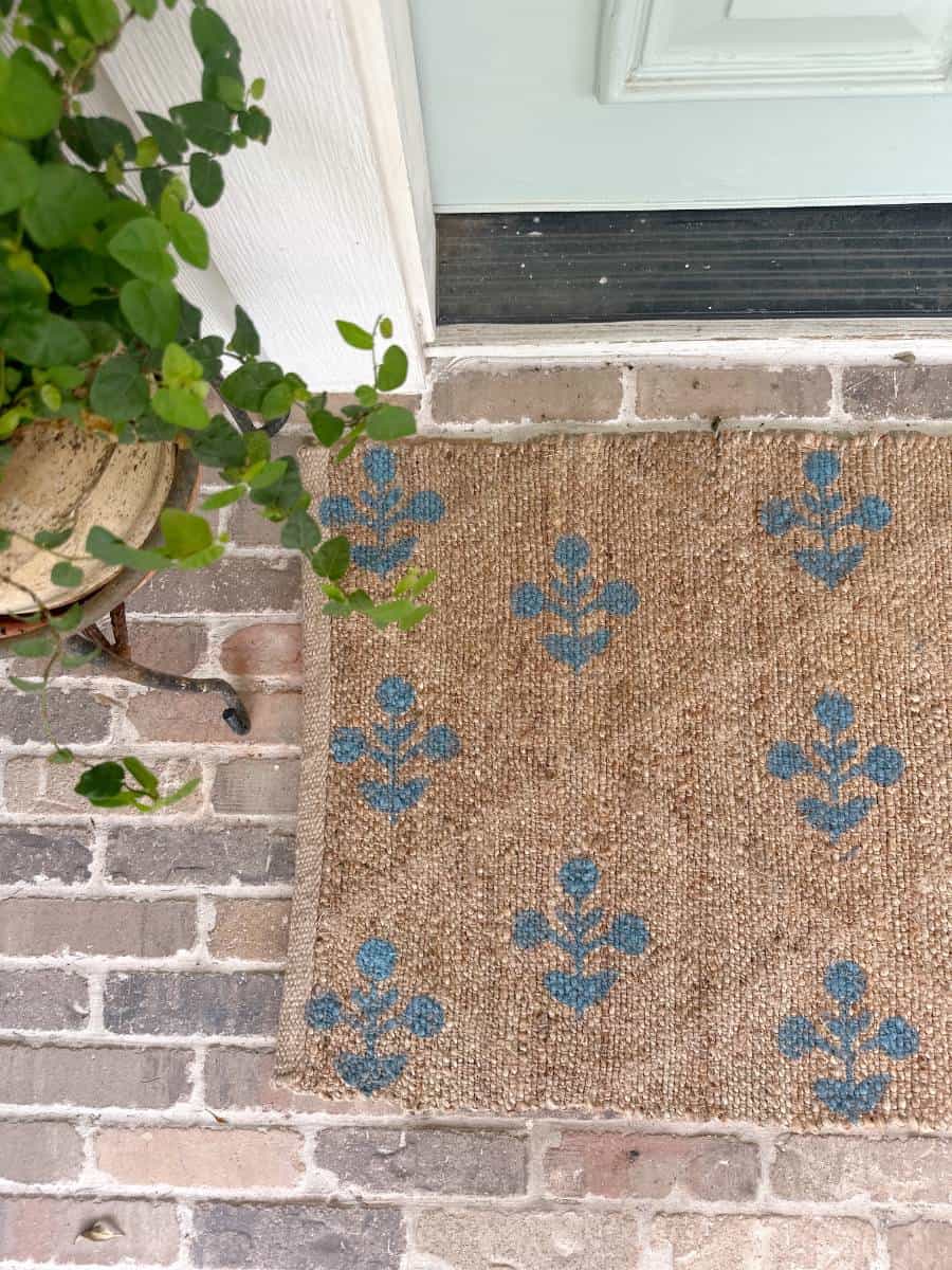 blue block print pattern on jute rug runner outside front light blue front door