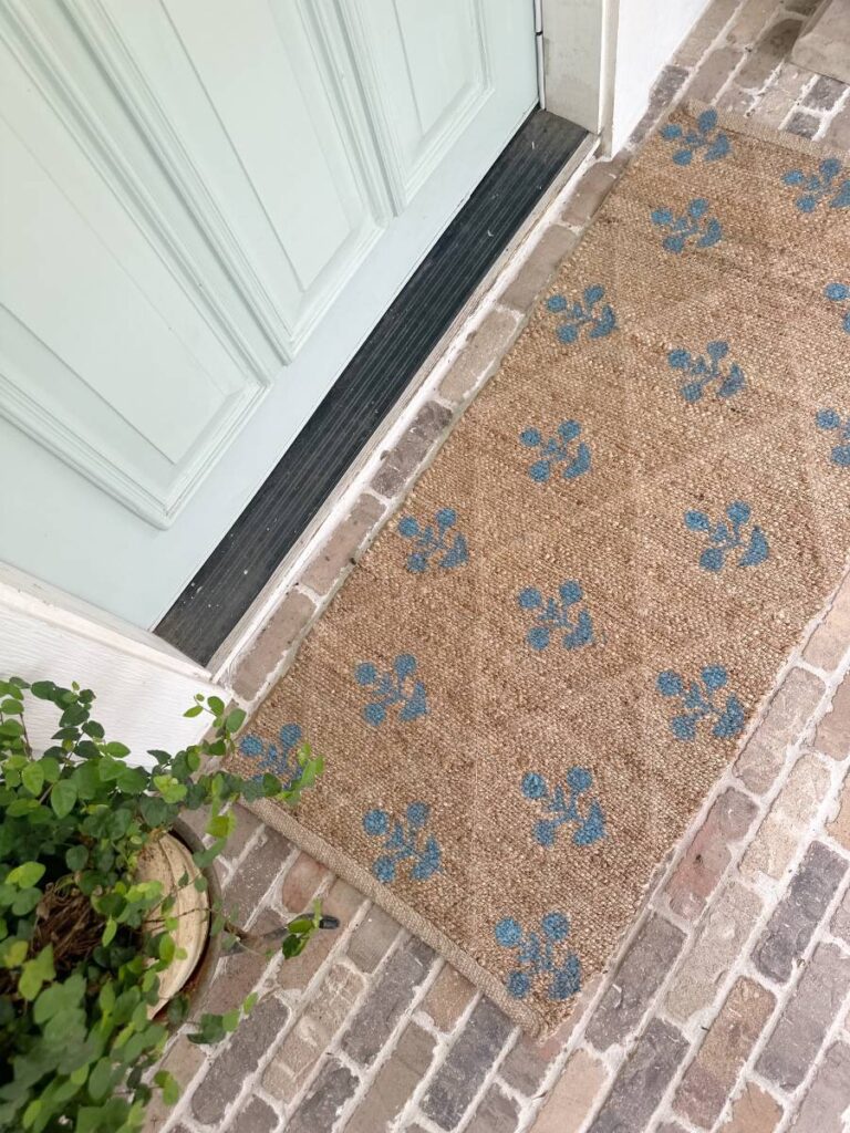 blue block print pattern on jute rug runner outside front light blue front door