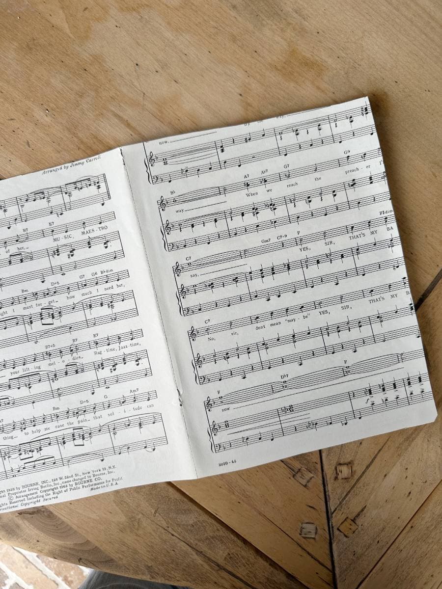 piece of sheet music opened up on wood table