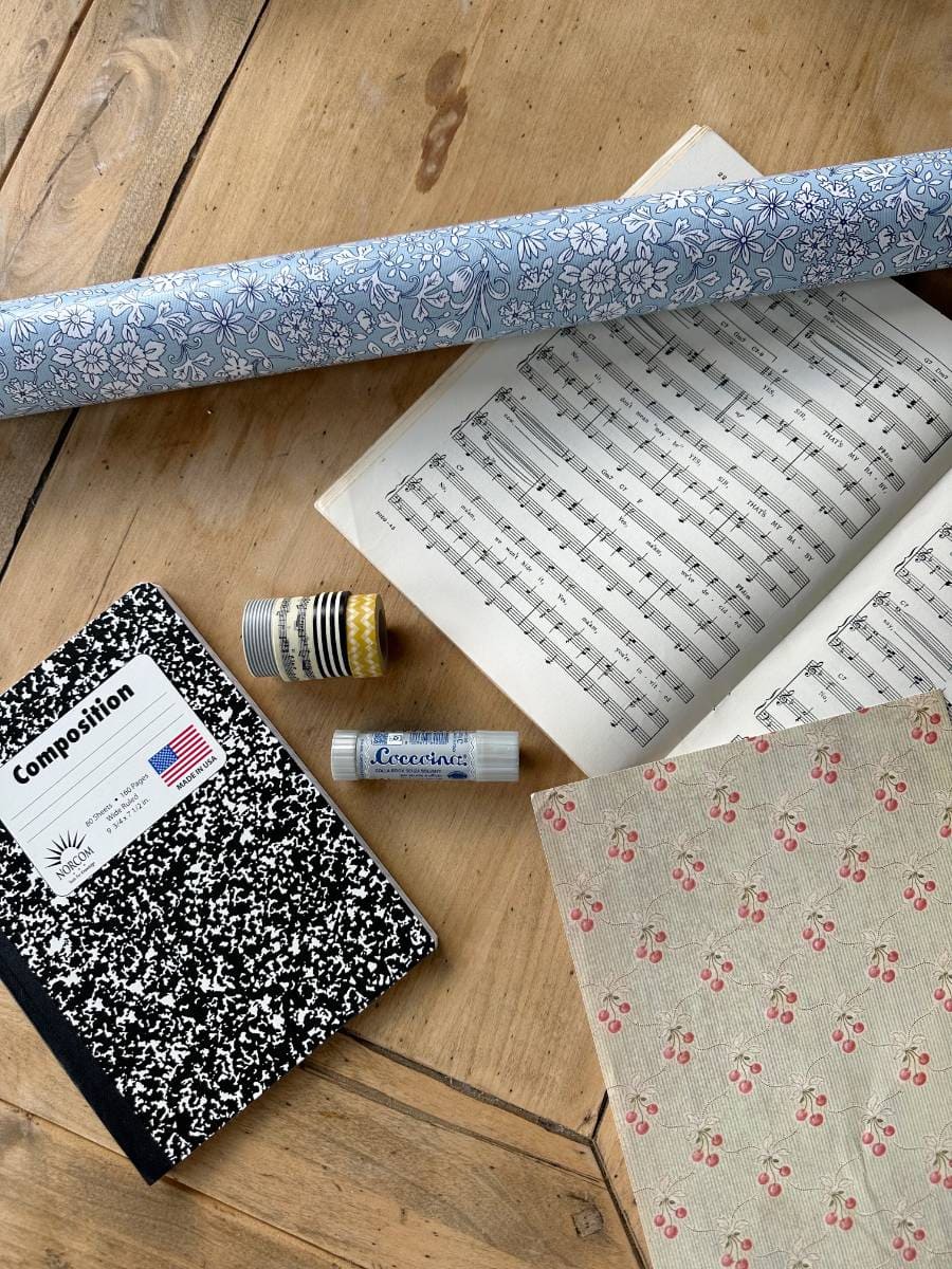 supplies for DIY for making personalized journal notebook composition notebook glue stick washi tape wrapping paper sheet music decorative paper