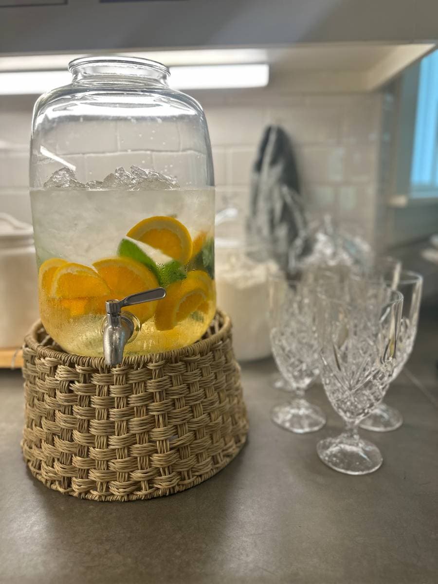 orange mint water in beverage jar on woven stand