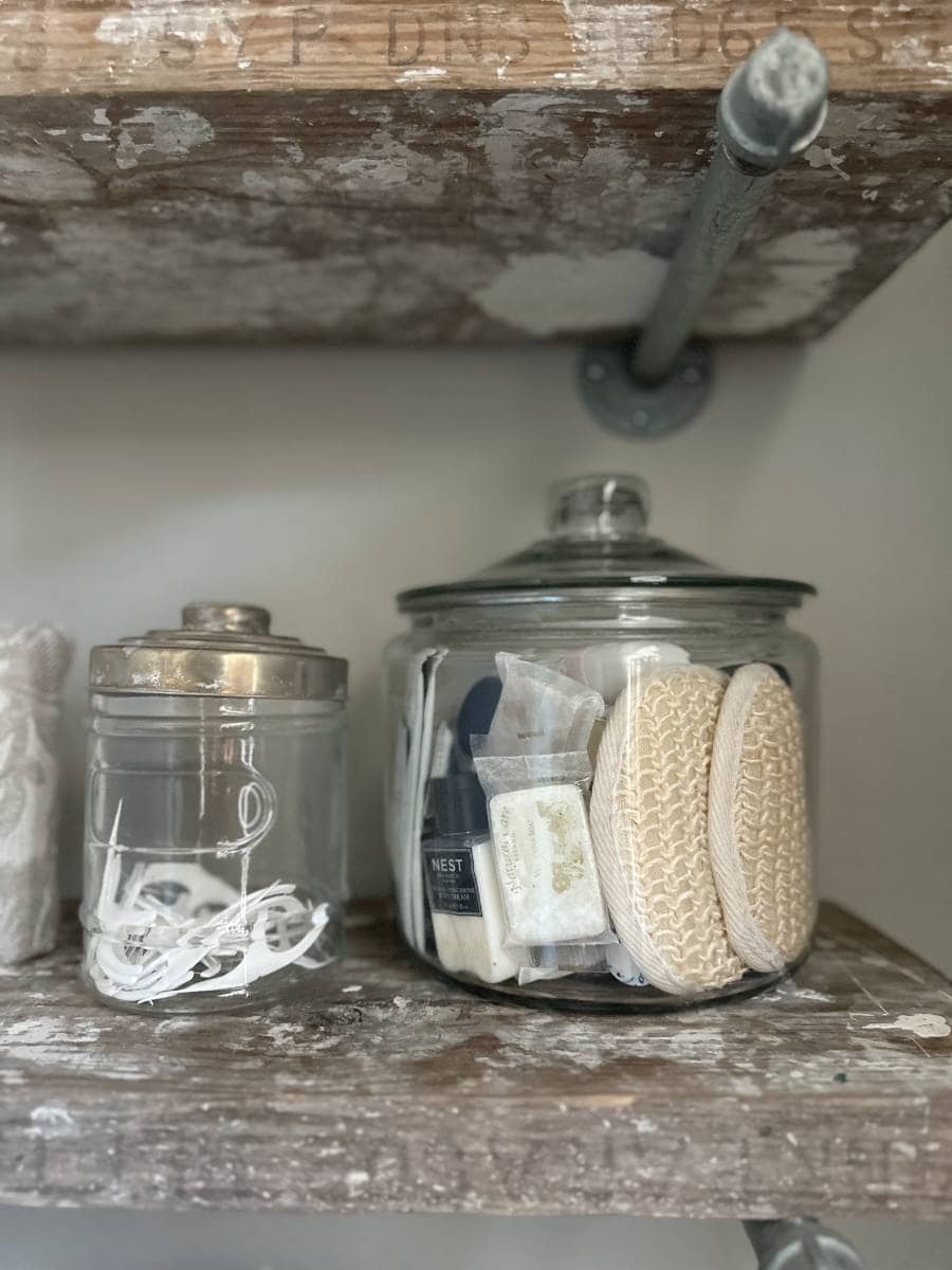 glass canister filled with bathroom essentials in guest bathroom