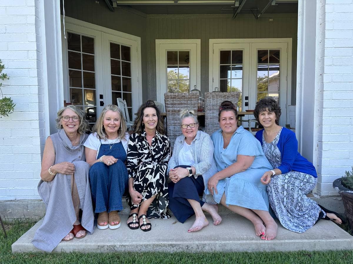 6 ladies sitting on steps at house