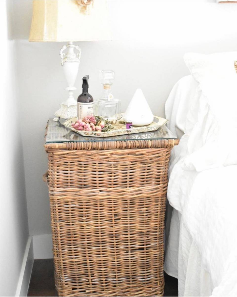 woven nightstand with lamp diffuser and flowers in guest room