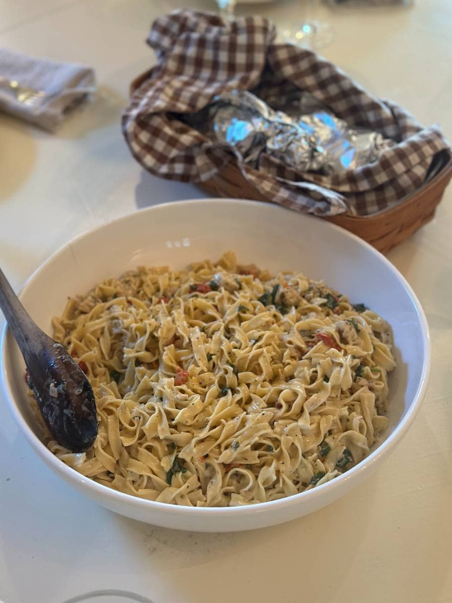 creamy chicken and sun dried tomatoe pasta in white serving bowl